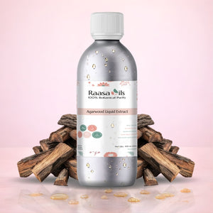 Bottle of Raasa Oils Agarwood Liquid Extract with wooden pieces on a pink background