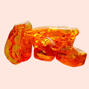 Three pieces of amber on a light pink background
