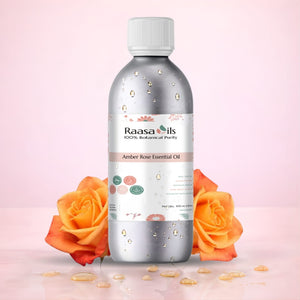 Bottle of Raasa Oils Amber Rose Essential Oil with orange roses on a pink background