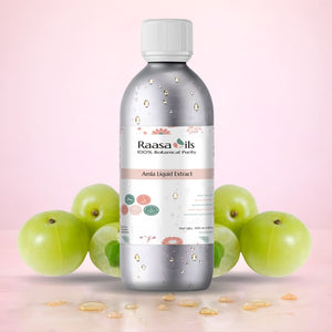 Bottle of Raasa Oils Amla Liquid Extract with gooseberries on a pink background