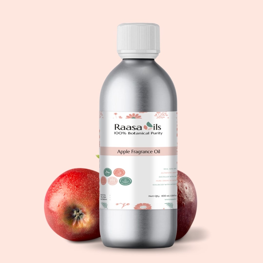 Bottle of Raasa Oils Apple Fragrance Oil with two apples on a beige background