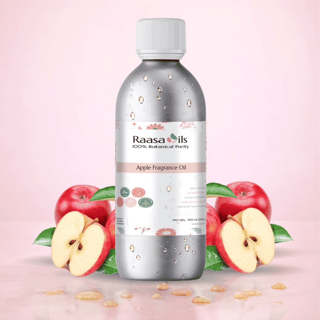 Bottle of Raasa Oils Apple Fragrance Oil with apples on a pink background