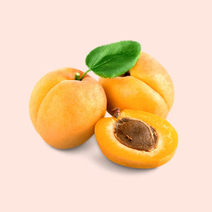Three apricots with a green leaf on a light pink background