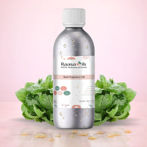 Bottle of Raasa Oils Basil Fragrance Oil with basil leaves on a pink background