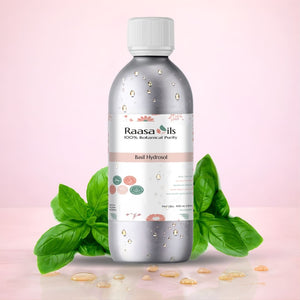 Bottle of Raasa Oils Basil Hydrosol with basil leaves on a pink background