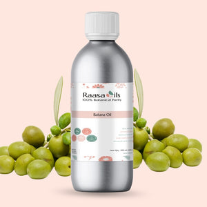 Bottle of Raasa Oils batana oil with batana leaves and fruit on a pink background