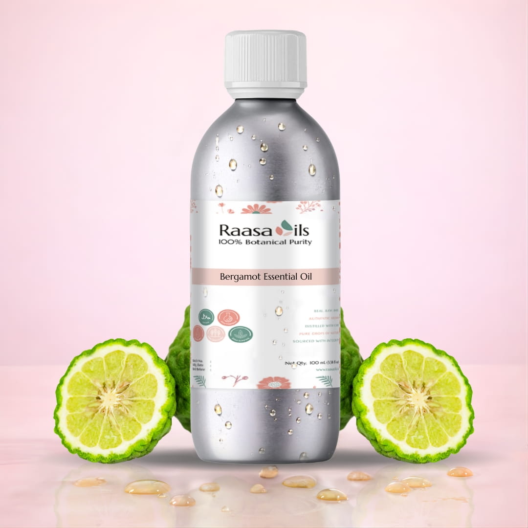 Bottle of Raasa Oils Bergamot Essential Oil with bergamot fruit slices on a pink background