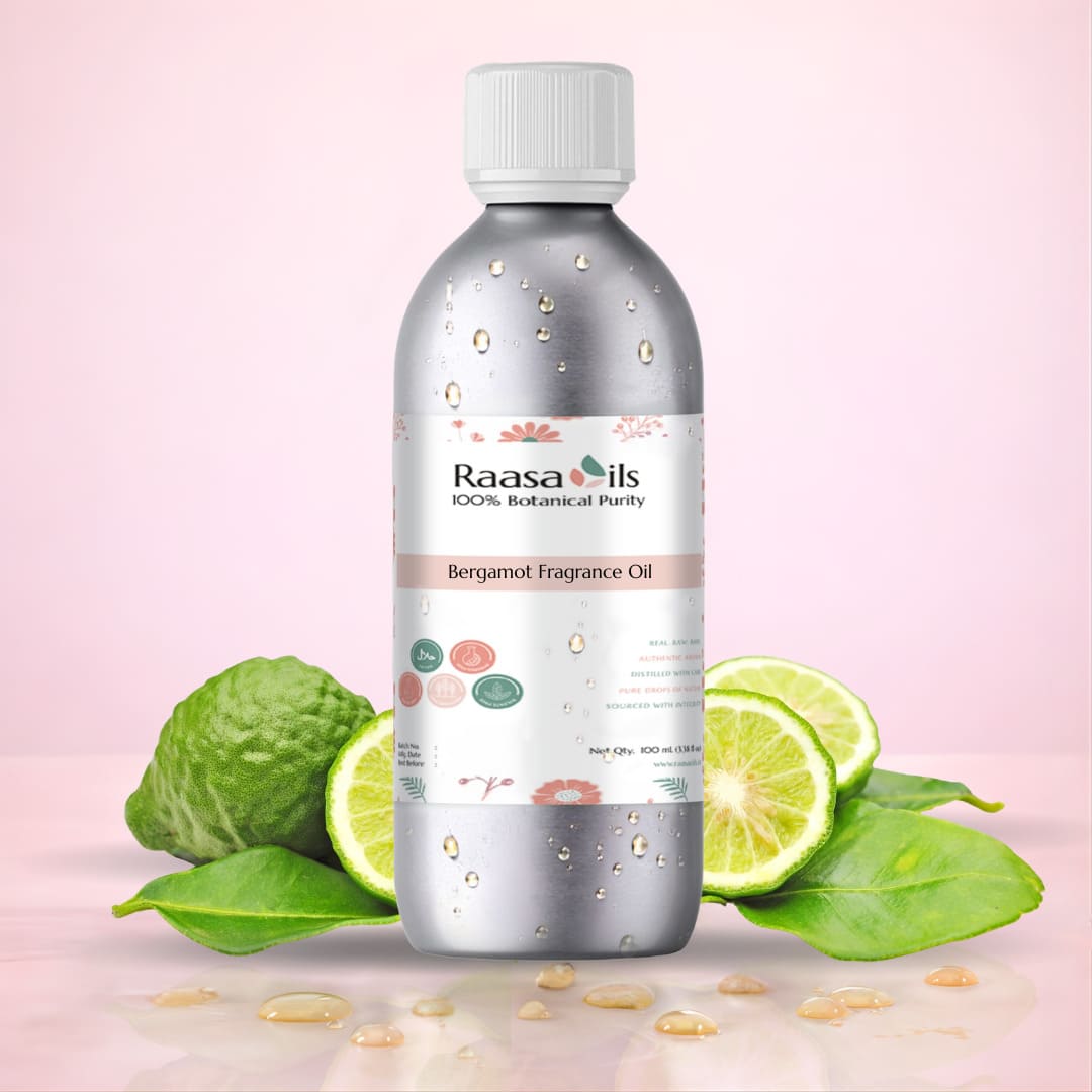 Bottle of Raasa Oils Bergamot Fragrance Oil with bergamot fruit and leaves on a pink background