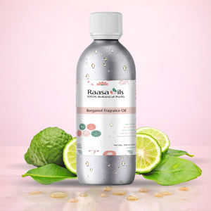 Bottle of Raasa Oils Bergamot Fragrance Oil with bergamot fruit and leaves on a pink background