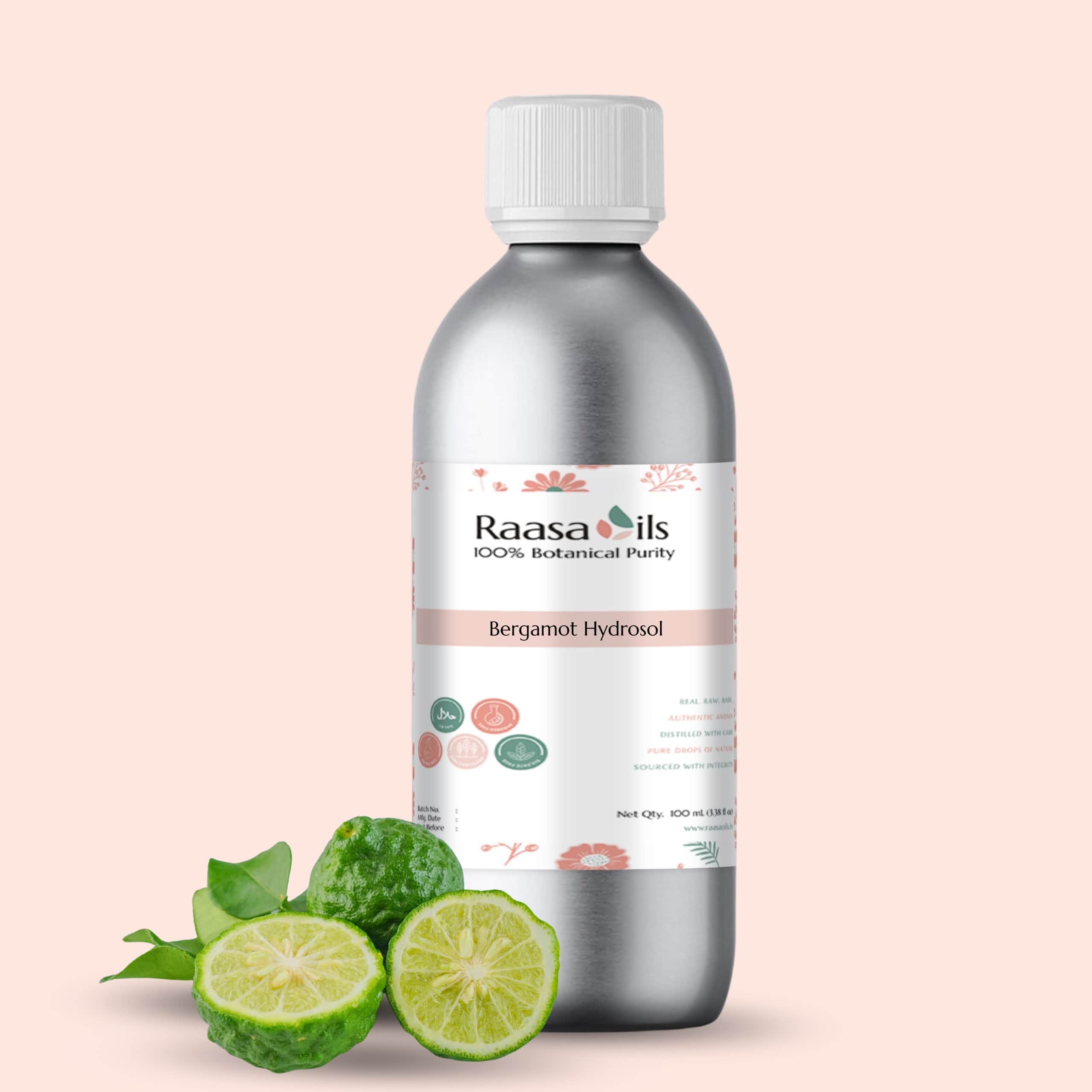 Bottle of Raasa Oils Bergamot Hydrosol with bergamot fruits on a light pink background