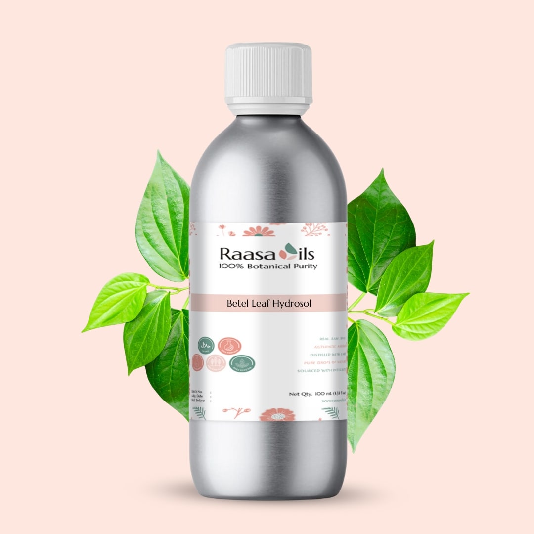 Bottle of Raasa Oils Betel Leaf Hydrosol with green leaves on a light pink background