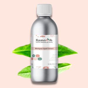 Bottle of Raasa Oils Bhringraj Liquid Extract with green leaves on a light pink background