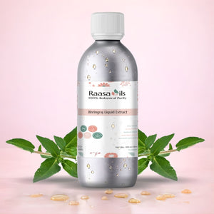 Bottle of Raasa Oils Bhringraj Liquid Extract with green leaves on a pink background