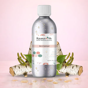 Bottle of Raasa Oils Birch Hydrosol with birch branches and leaves on a pink background