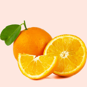 Whole and sliced oranges on a pink background