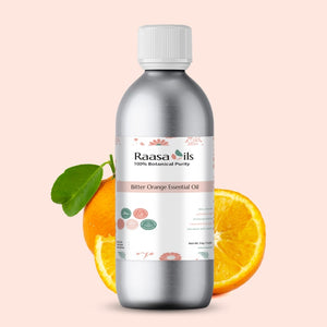 Bottle of Raasa Oils Bitter Orange Essential Oil with oranges on a beige background