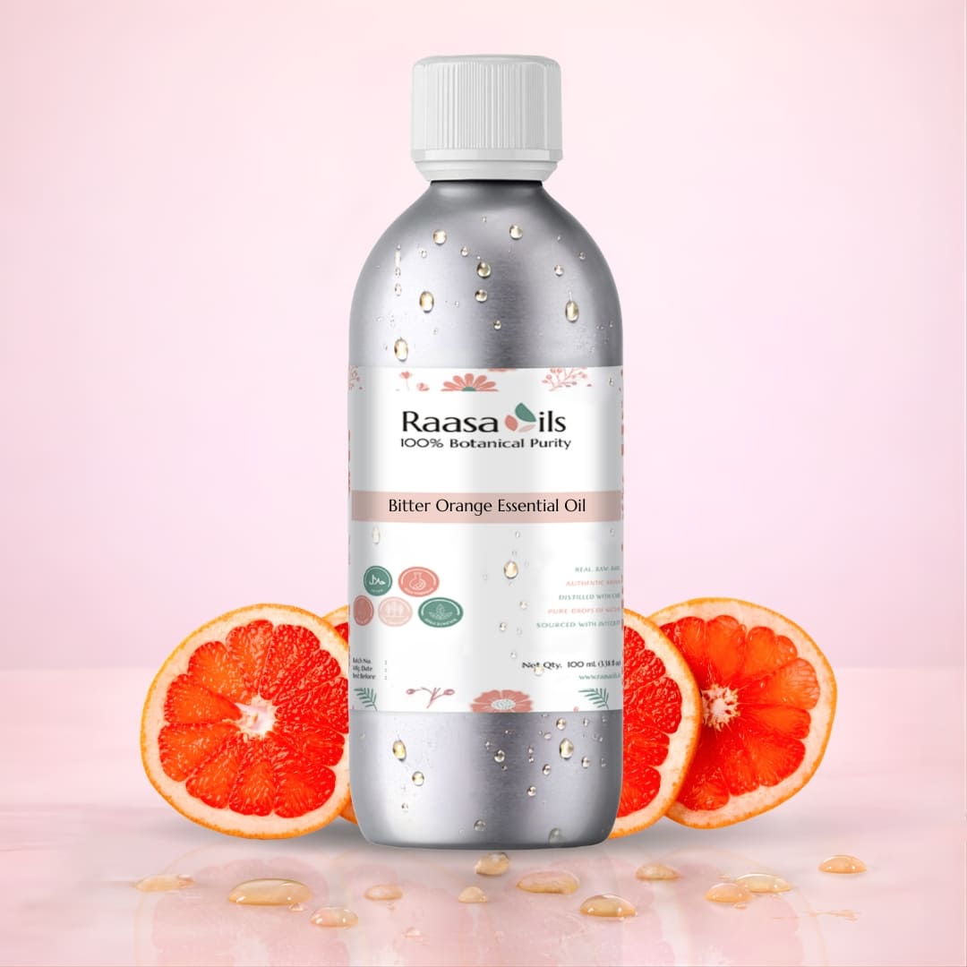 Bottle of Raasa Oils Bitter Orange Essential Oil with orange slices on a pink background