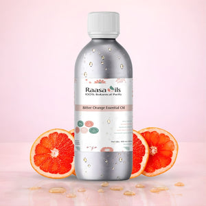 Bottle of Raasa Oils Bitter Orange Essential Oil with orange slices on a pink background