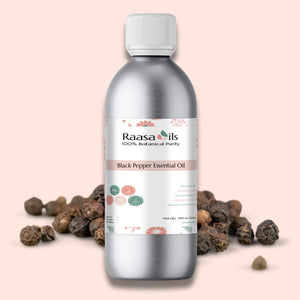 Bottle of Raasa Oils Black Pepper Essential Oil with black peppercorns on a light pink background