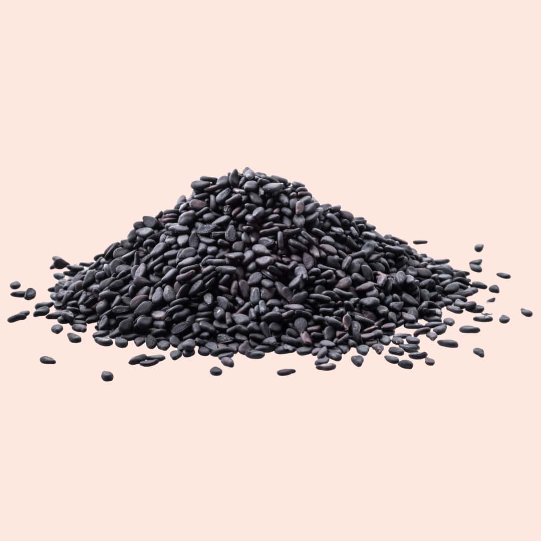Pile of black seeds on a beige background