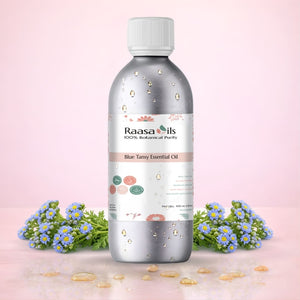 Raasa Oils Blue Tansy Essential Oil bottle with flowers on a pink background