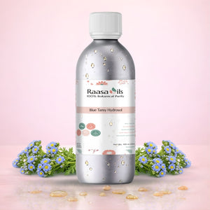 Bottle of Raasa Oils with blue flowers on a pink background