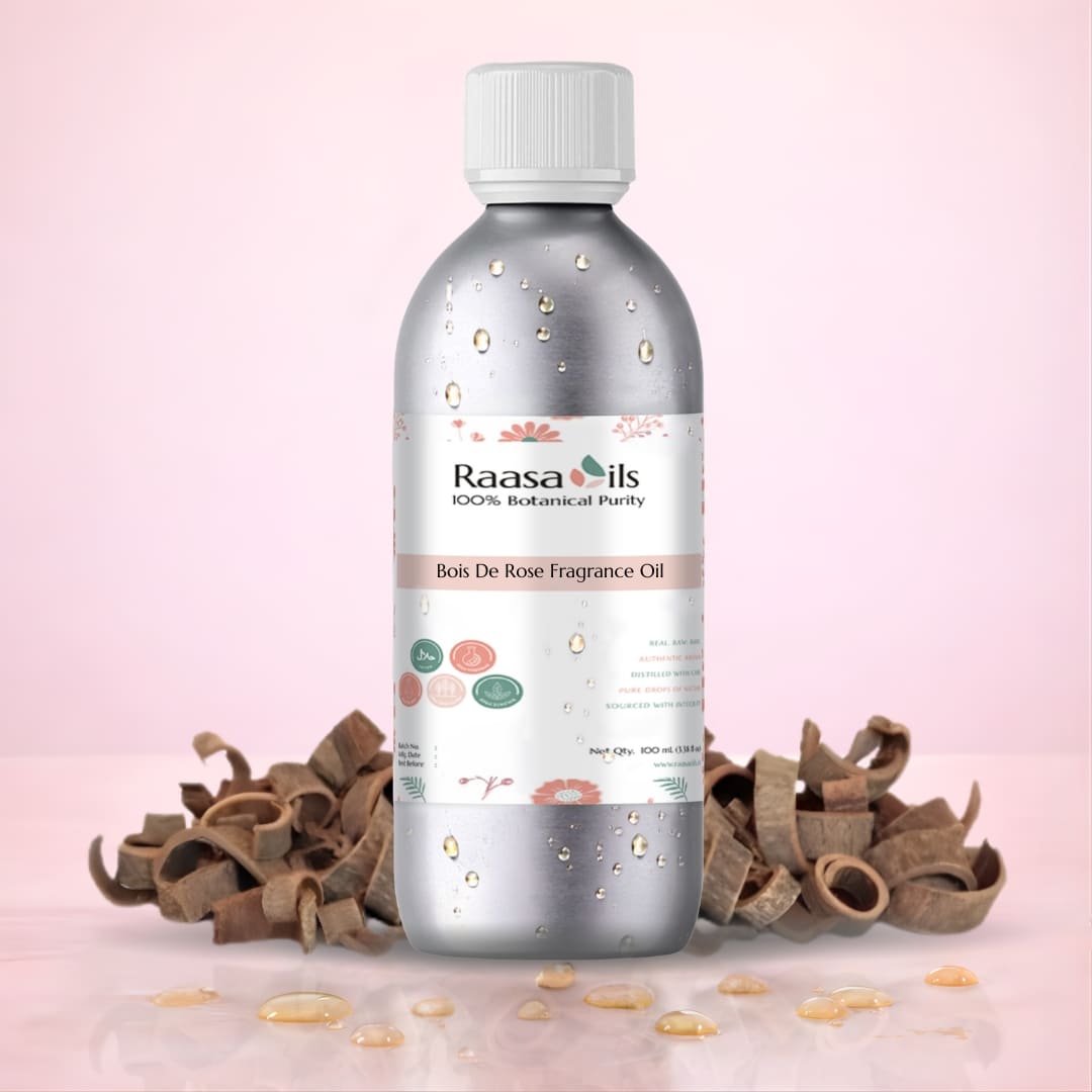 Bottle of Raasa Oils Bois De Rose Fragrance Oil on a pink background with cinnamon sticks.
