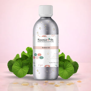 Bottle of Raasa Oils Brahmi Oil with green leaves on a pink background