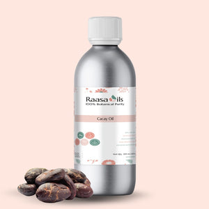 Bottle of Raasa Oils Cacay Oil with cacao beans on a beige background
