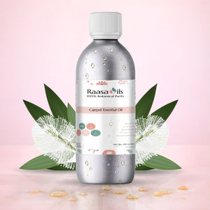 Raasa Oils Cajeput Essential Oil bottle with leaves and flowers on a pink background