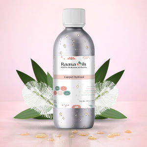 Bottle of Raasa Oils Caieput Hydrosol with leaves and flowers on a pink background