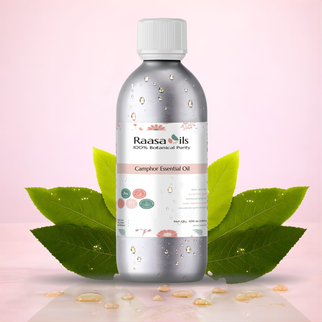 Raasa Oils Camphor Essential Oil bottle with green leaves on a pink background