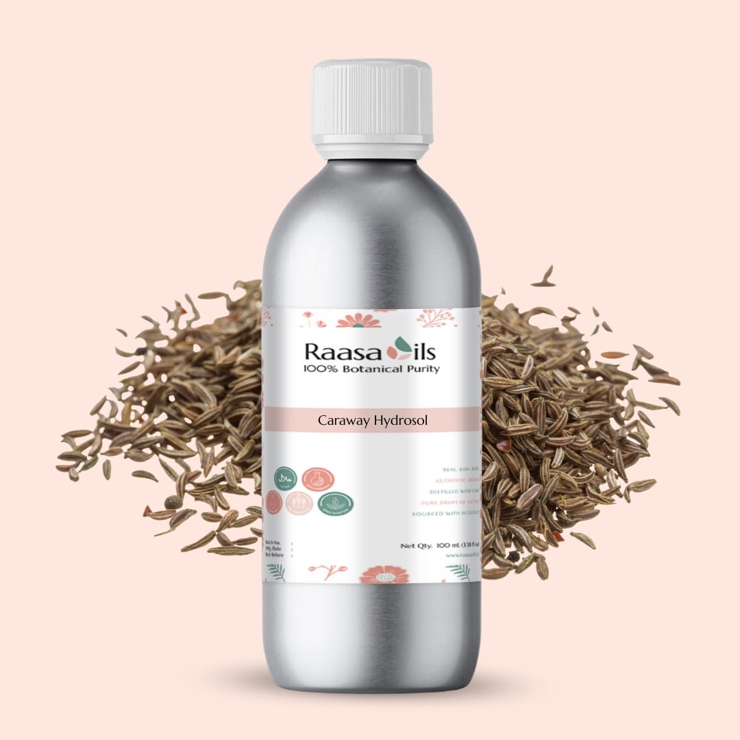 Raasa Oils caraway hydrosol bottle with caraway seeds on a light pink background