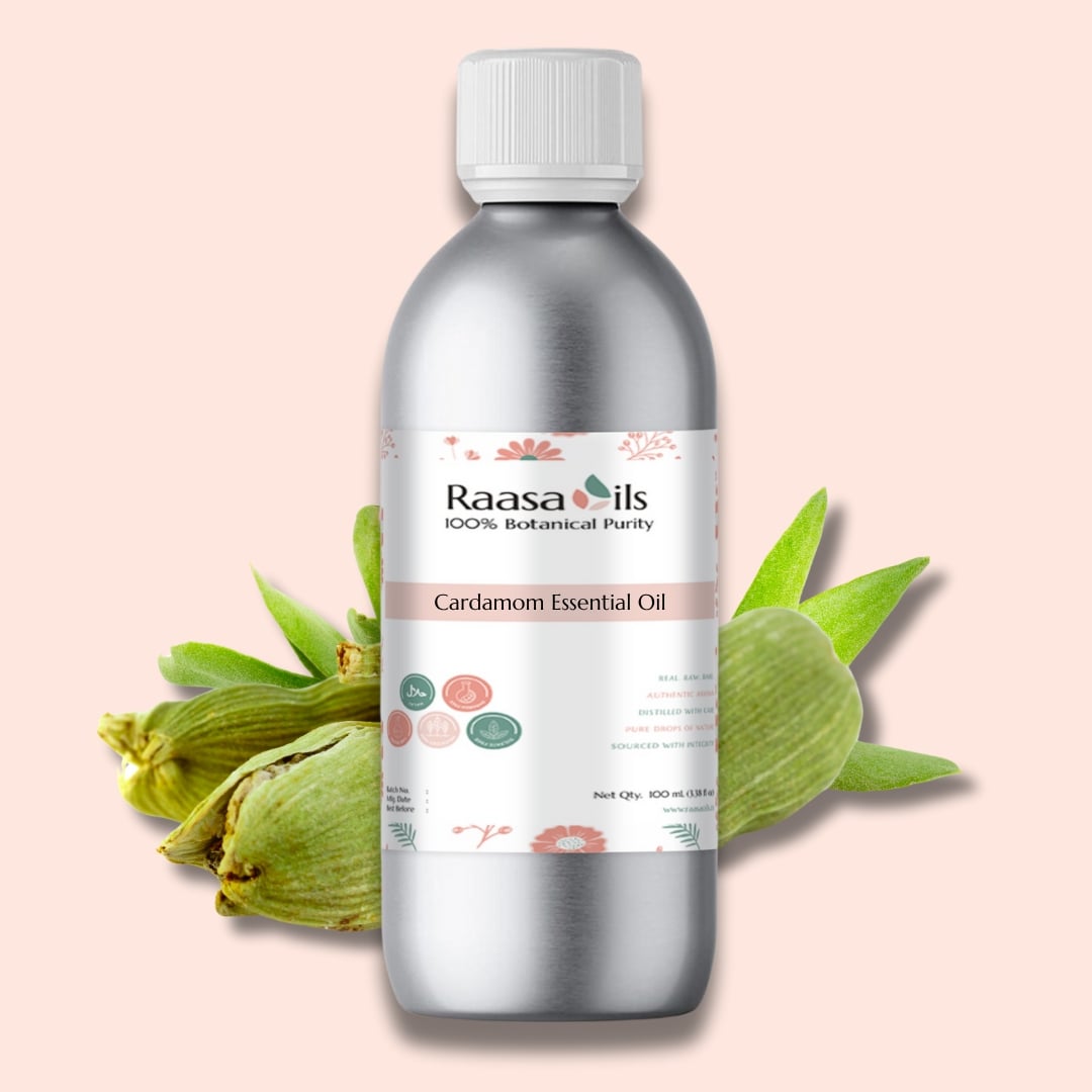Bottle of Raasa Oils Cardamom Essential Oil with cardamom leaves on a light pink background