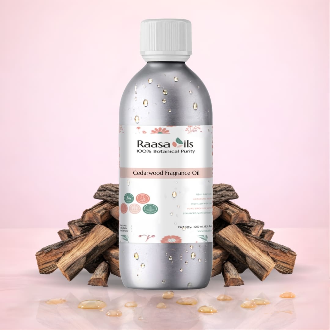 Bottle of Raasa Oils Cedarwood Fragrance Oil with wooden logs on a pink background