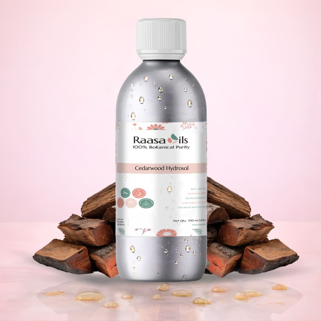 Bottle of Raasa Oils Cedarwood Hydrosol with wooden pieces on a pink background