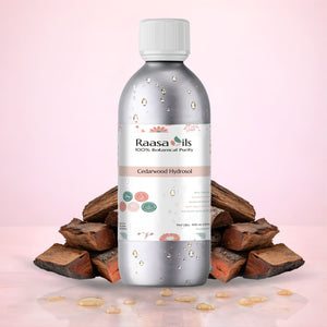 Bottle of Raasa Oils Cedarwood Hydrosol with wooden pieces on a pink background