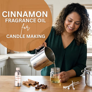 Woman pouring cinnamon fragrance oil into a jar with cinnamon sticks and a bottle on a table.