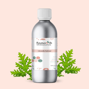 Bottle of Raasa Oils Citronella Hydrosol with green leaves on a light pink background