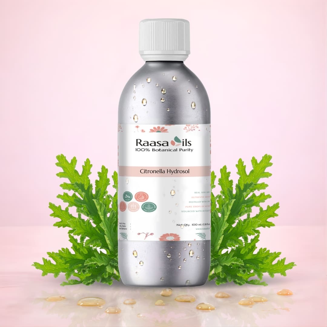 Bottle of Raasa Oils Citronella Hydrosol with green leaves on a pink background