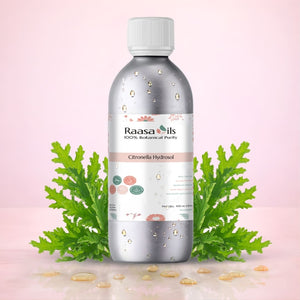 Bottle of Raasa Oils Citronella Hydrosol with green leaves on a pink background