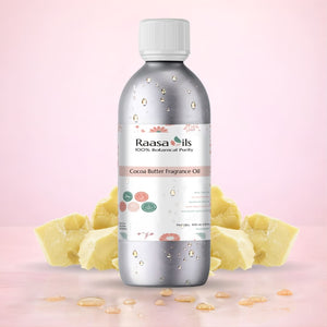 Bottle of Raasa Oils Cocoa Butter Fragrance Oil with cocoa butter pieces on a pink background