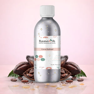 Bottle of Raasa Oils Cocoa Hydrosol with cocoa beans on a pink background