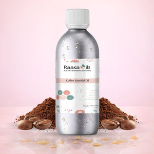 Raasa Oils Coffee Essential Oil bottle with coffee beans and grounds on a pink background