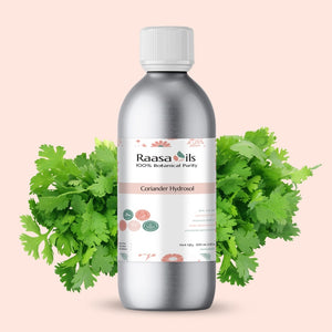 Bottle of Raasa Oils Coriander Hydrosol with coriander leaves on a light pink background