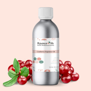 Bottle of Raasa Oils Cranberry Fragrance Oil with cranberries and leaves on a beige background