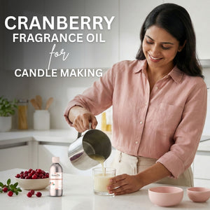 Woman pouring liquid into a glass with cranberry fragrance oil for candle making.