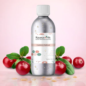 Raasa Oils Cranberry Hydrosol bottle with cranberries and leaves on a pink background