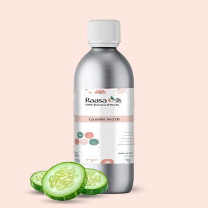 Bottle of Raasa Oils Cucumber Seed Oil with slices of cucumber on a beige background