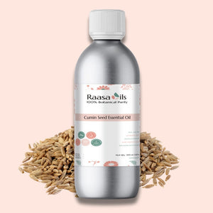 Raasa Oils Cumin Seed Essential Oil bottle with cumin seeds on a pink background